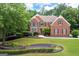 Beautiful two story brick home with lush green front lawn and manicured landscaping at 3045 Moss Stone Lane Sw Ln, Marietta, GA 30064