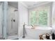 The luxurious main bathroom boasts a standalone tub, walk-in shower, and bright natural light at 3045 Moss Stone Lane Sw Ln, Marietta, GA 30064