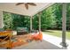 Covered patio area provides an outdoor living space, nestled among mature trees at 3045 Moss Stone Lane Sw Ln, Marietta, GA 30064