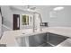 Modern kitchen island with stainless steel sink and faucet, complemented by natural light and a cozy fireplace view at 569 Middle Sw St, Atlanta, GA 30310