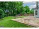 Backyard featuring a stone patio, hot tub, fire pit, and mature trees for shade and privacy at 10980 Pinehigh Dr, Alpharetta, GA 30022