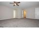 Spacious carpeted primary bedroom featuring a ceiling fan and multiple doorways at 10980 Pinehigh Dr, Alpharetta, GA 30022
