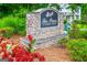 Stone community sign for The Pines at Kimball Bridge with colorful landscaping and a glimpse of homes at 10980 Pinehigh Dr, Alpharetta, GA 30022