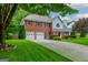 Charming two-story home with a well-manicured lawn, a brick facade, and an attached two-car garage at 10980 Pinehigh Dr, Alpharetta, GA 30022