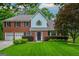 Beautiful home featuring a manicured front lawn, a brick facade, and an attached two-car garage at 10980 Pinehigh Dr, Alpharetta, GA 30022