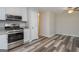 Kitchen area with stainless appliances, granite counters, and stylish wood-look flooring at 10980 Pinehigh Dr, Alpharetta, GA 30022