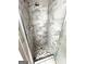 Shower with marble-look tile surround and stone pebble flooring at 10980 Pinehigh Dr, Alpharetta, GA 30022