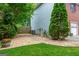 Side yard with gravel walkway, stepping stones, manicured landscaping, and privacy fence at 10980 Pinehigh Dr, Alpharetta, GA 30022