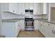 Well-lit kitchen featuring ample white cabinetry, subway tile backsplash, granite countertops, and stainless steel appliances at 110 Chesterfield Ct, Fayetteville, GA 30214