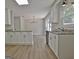 Open-concept kitchen features granite counters, white cabinets and appliances and view into the dining area at 110 Chesterfield Ct, Fayetteville, GA 30214
