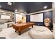 Spacious basement area with projector screen, pool table, and comfortable beanbag seating for relaxation at 2230 Cambridge Hill Ct, Dacula, GA 30019