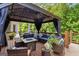 Inviting outdoor deck with covered seating area, fire pit table, and lush greenery for a relaxing retreat at 2230 Cambridge Hill Ct, Dacula, GA 30019