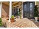 Inviting front porch with brick flooring, stone accents, and elegant double doors at 2230 Cambridge Hill Ct, Dacula, GA 30019