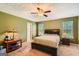 Carpeted bedroom featuring a ceiling fan and a dark wood bed frame at 180 Moseley Crossing Dr, Stockbridge, GA 30281