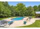 Sparkling in-ground pool surrounded by lush landscaping and ample lounge seating at 180 Moseley Crossing Dr, Stockbridge, GA 30281
