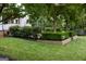 Landscaped backyard with manicured lawn, lush trees, hedges and flowers for outdoor enjoyment at 7093 Vaughn Rd, Canton, GA 30115