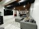 Finished basement area with gray sofa, tv, brick accent wall and bar with arcade sign for entertainment at 7093 Vaughn Rd, Canton, GA 30115