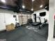 Home gym with treadmill, rower, weights, exposed ductwork, brick accent wall and tv at 7093 Vaughn Rd, Canton, GA 30115