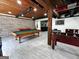 Finished basement features a pool table, foosball table, bar and brick accent wall at 7093 Vaughn Rd, Canton, GA 30115