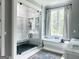 Stunning bathroom features a walk-in shower, soaking tub, window, and marble countertops at 7093 Vaughn Rd, Canton, GA 30115