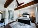 Beautiful bedroom boasts wood beams, ceiling fan, ensuite bath, and hardwood floors at 7093 Vaughn Rd, Canton, GA 30115