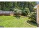 Grassy backyard surrounded by a privacy fence and mature trees, perfect for outdoor enjoyment at 1055 Avalon Dr, Lawrenceville, GA 30044