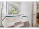 Luxurious soaking tub beneath a bright window, offering a peaceful retreat within the bathroom at 1055 Avalon Dr, Lawrenceville, GA 30044