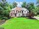 Traditional brick home featuring manicured front lawn and mature trees at 121 Fairway Overlook, Woodstock, GA 30188