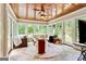 Cozy sunroom featuring tiled floor, wood paneled ceiling and multiple windows overlooking the backyard at 121 Fairway Overlook, Woodstock, GA 30188