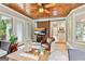 Inviting sunroom with wood ceiling, sliding barn door, comfortable seating, and scenic views at 121 Fairway Overlook, Woodstock, GA 30188