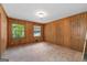 Bedroom featuring wood paneling, natural light from two windows, and multiple closet doors at 2917 Rockingham Nw Dr, Atlanta, GA 30327