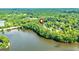 Picturesque aerial view of 115 Edgewater Way nestled on the shores of a serene lake surrounded by lush greenery at 115 Edgewater Way, Peachtree City, GA 30269