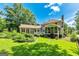 Beautifully landscaped backyard with mature trees, lush lawn, patio, and screened porch, perfect for outdoor living at 115 Edgewater Way, Peachtree City, GA 30269