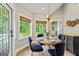 Cozy breakfast nook with a round table, comfortable seating, and large windows offering serene views of the outdoors at 115 Edgewater Way, Peachtree City, GA 30269