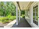 Inviting covered porch with wood floors, white columns, ceiling fan, and manicured landscaping, enhancing curb appeal at 115 Edgewater Way, Peachtree City, GA 30269