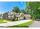 Charming exterior featuring a multi-car garage, mature trees, landscaped yard, and inviting driveway, enhancing curb appeal at 115 Edgewater Way, Peachtree City, GA 30269