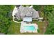 An aerial view showcases the backyard pool and spa of the home surrounded by lush green landscaping at 310 Westbourne Dr, Tyrone, GA 30290