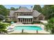 A backyard pool and spa is complemented by the home's manicured lawn and mature landscaping at 310 Westbourne Dr, Tyrone, GA 30290