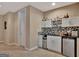 Basement bar area with white cabinets, mini fridge, and stylish backsplash at 310 Westbourne Dr, Tyrone, GA 30290