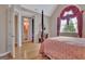 Well-lit bedroom showcases a four-poster bed and open doorway to a bathroom and a closet at 310 Westbourne Dr, Tyrone, GA 30290