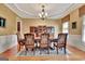Formal dining room with crown molding, designer paint, elegant chandelier, and ornate wood furnishings at 310 Westbourne Dr, Tyrone, GA 30290