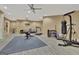 Spacious exercise room with padded floor, various gym equipment, and ceiling fan for air circulation at 310 Westbourne Dr, Tyrone, GA 30290
