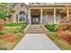 Elegant brick home featuring a covered front porch with decorative columns and an ornate front door at 310 Westbourne Dr, Tyrone, GA 30290