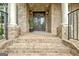 Close-up of a brick home's arched front porch with an ornate door and sconce lighting at 310 Westbourne Dr, Tyrone, GA 30290