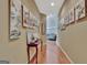 Long hallway with hardwood floors, art on the walls, and a table against the wall at 310 Westbourne Dr, Tyrone, GA 30290