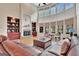 Open living room with a stone fireplace, built-in shelves, large windows, and a cozy seating area at 310 Westbourne Dr, Tyrone, GA 30290