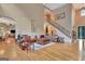 A sun-drenched living room features a large leather sectional sofa and open access to the staircase at 310 Westbourne Dr, Tyrone, GA 30290