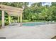 Covered pergola area with lounge seating provides shade beside the pool area at 310 Westbourne Dr, Tyrone, GA 30290