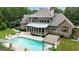 An aerial view of a pool, spa, screened in porch, pergola, and well manicured backyard at 310 Westbourne Dr, Tyrone, GA 30290