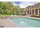 A beautiful backyard pool features lounge seating, spa, and manicured landscaping at 310 Westbourne Dr, Tyrone, GA 30290